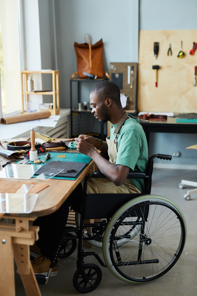 vertical-full-length-portrait-young-africanamerican-man-wheelchair-making-handmade-bag-leat